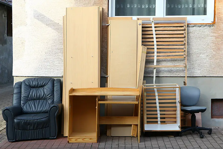 Sperrmüll aller Art stet vor einem Haus am Straßenrand