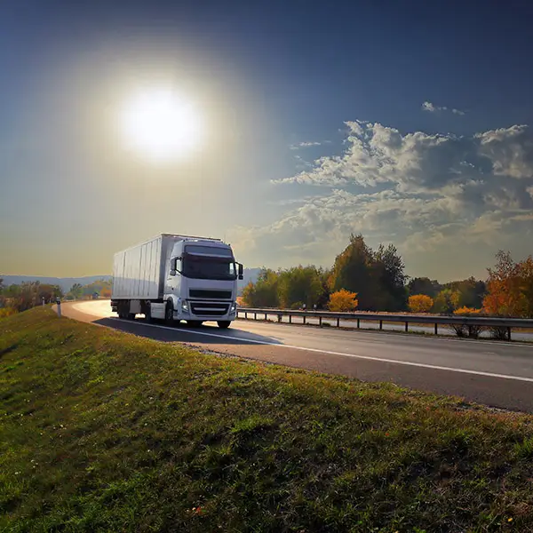 Umzugswagen auf einer Landstraße vor sattem blauem Himmel mit Sonnenschein